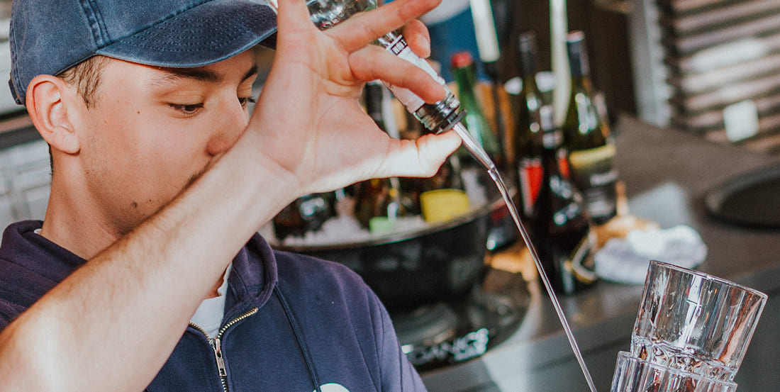 Barkeeper gießt stilvoll Drinks ein an der Bar der Weitmoserin
