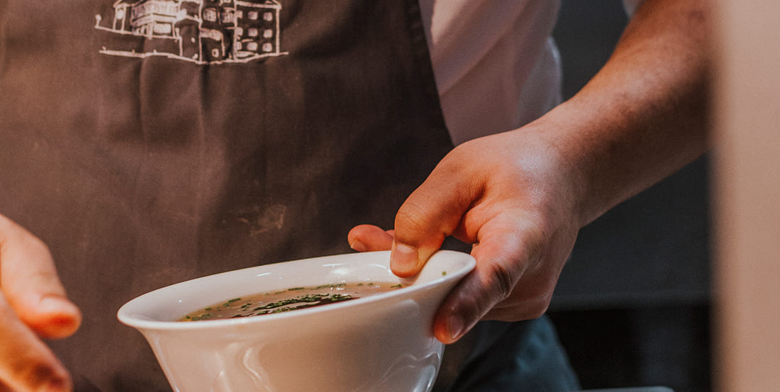 Küchenchef serviert frische Suppe im Restaurant Weitmoserin, Bad Hofgastein